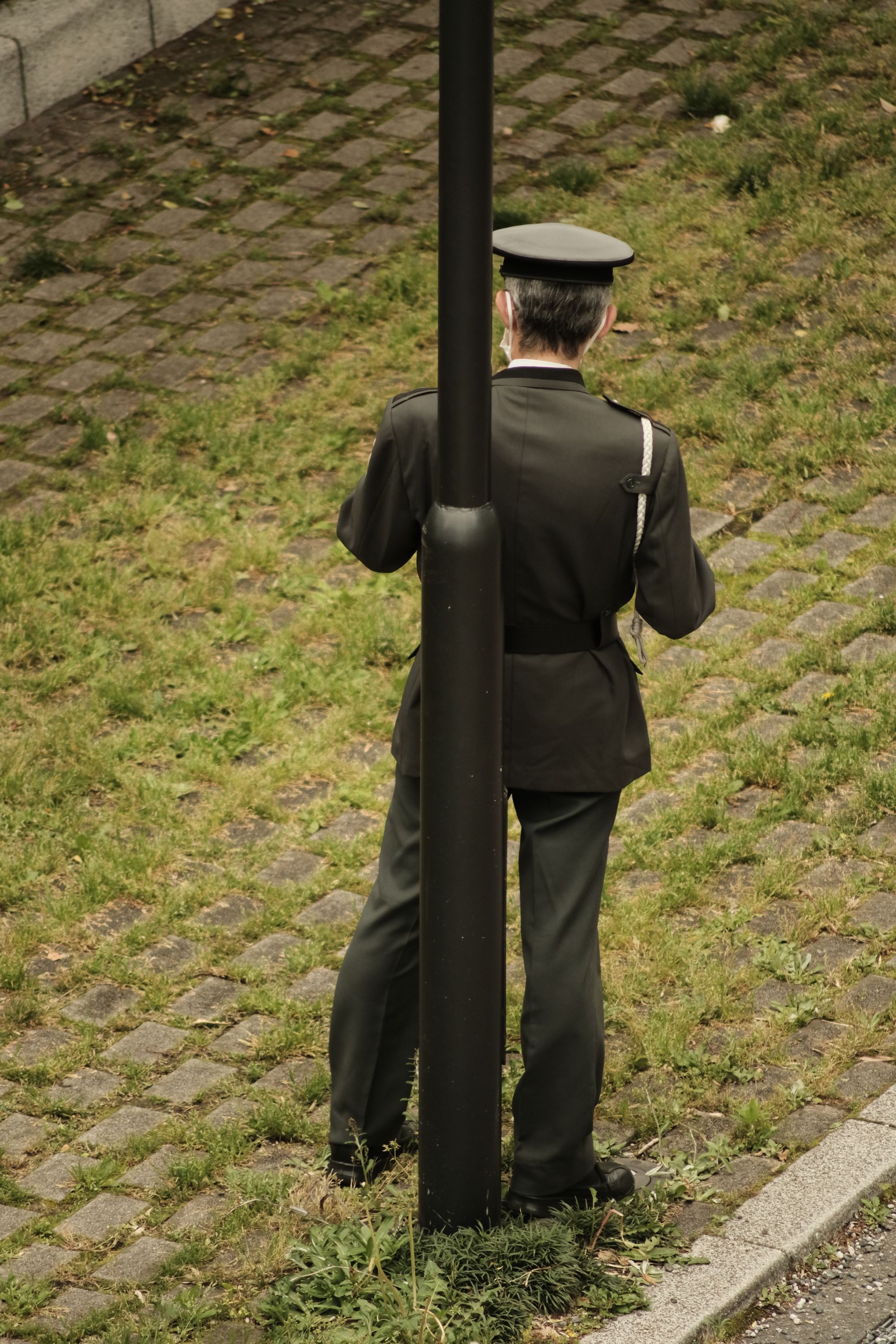 Japanese security guard next to a pole