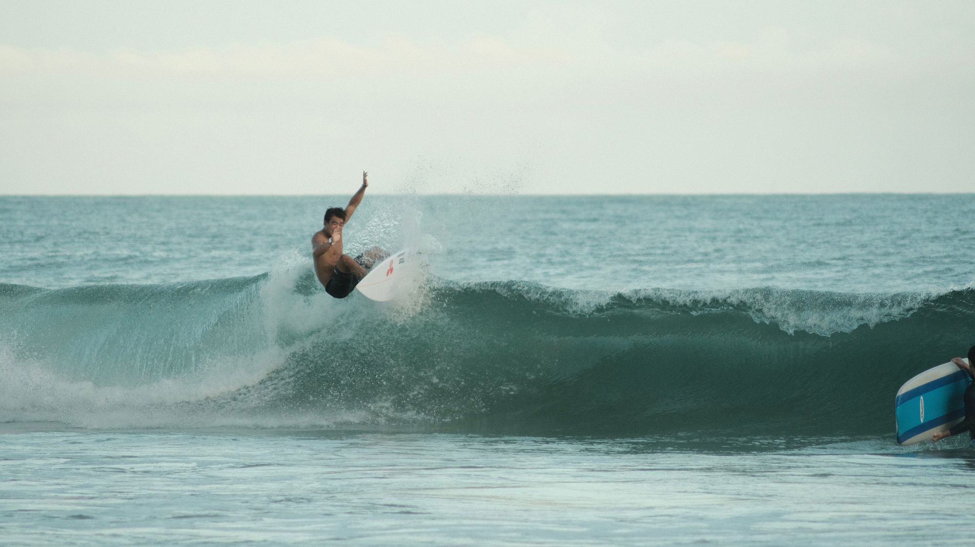 Surfer doing a top turn at golden hour in Onjuku, Japan