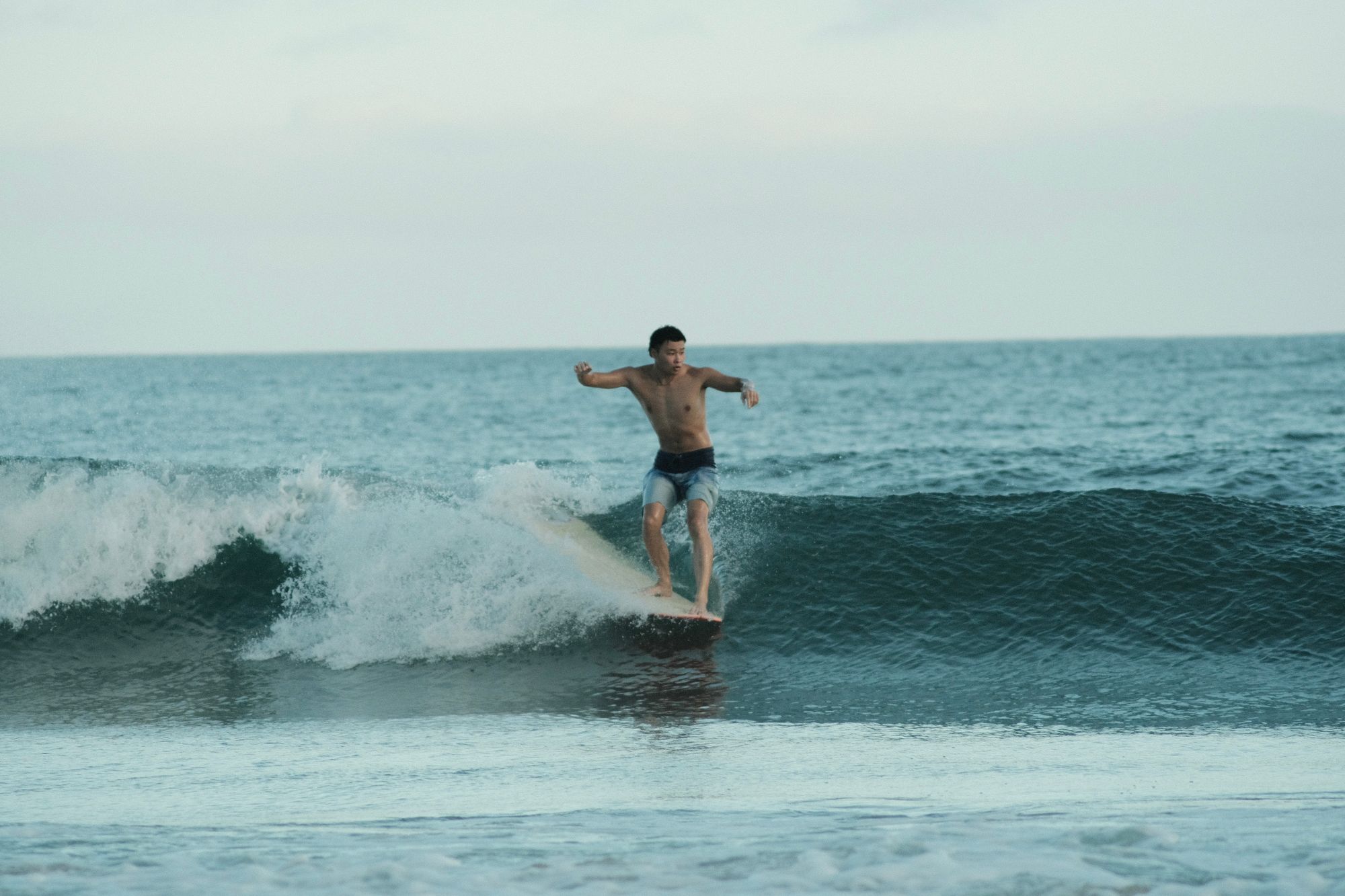 Surfer noseriding at golden hour in Onjuku, Japan