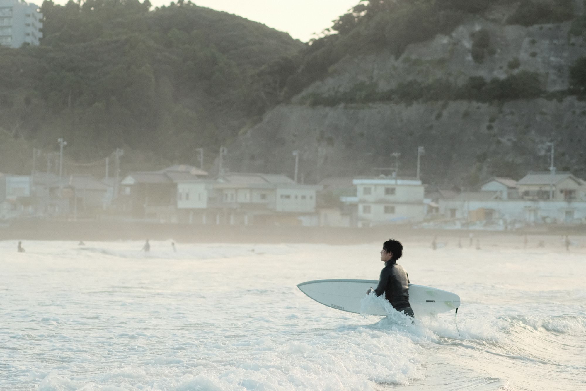 Surfer holding its board at golden hour in Onjuku, Japan