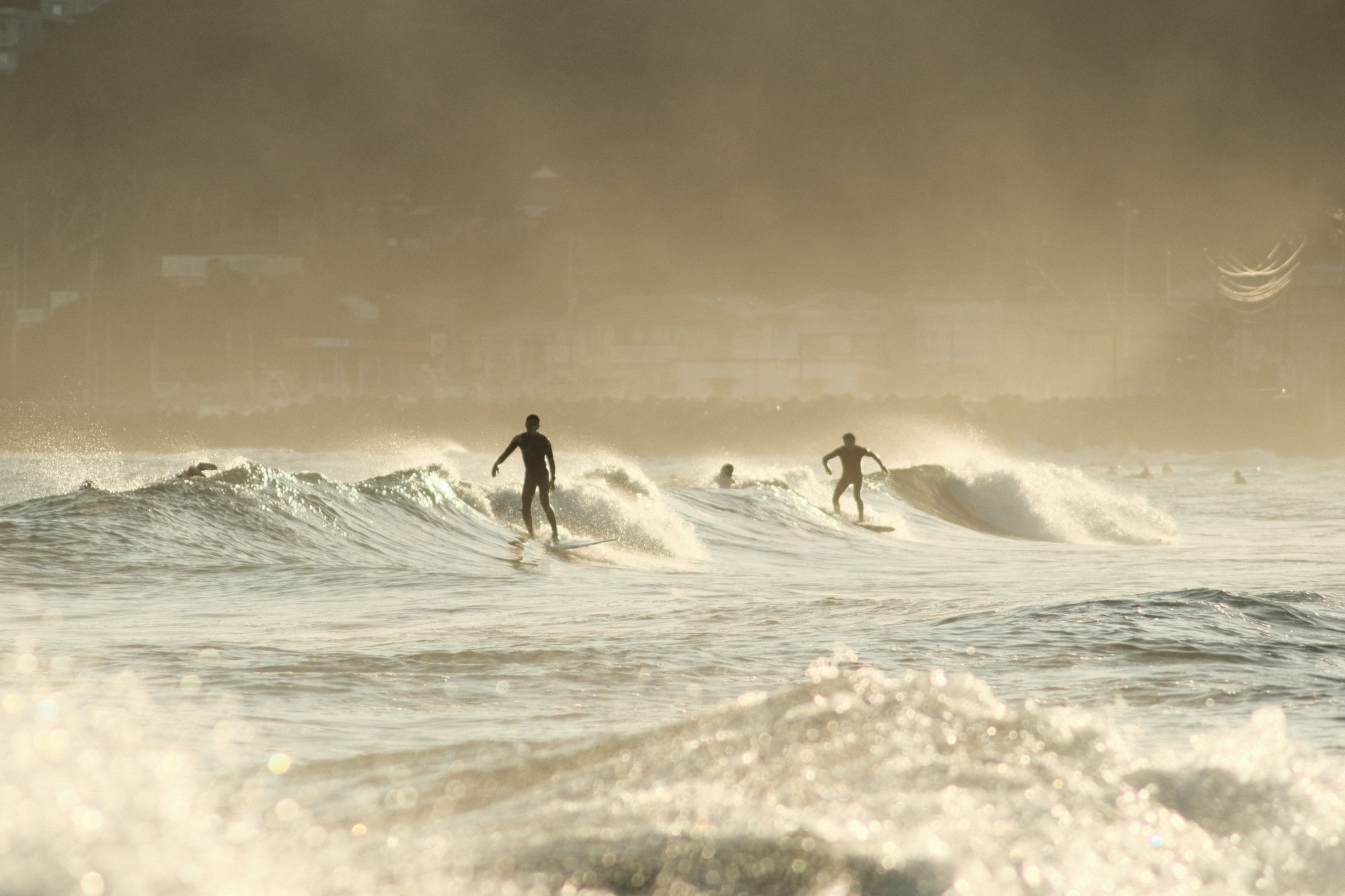 2 surfers on a wave at golden hour in Onjuku, Japan