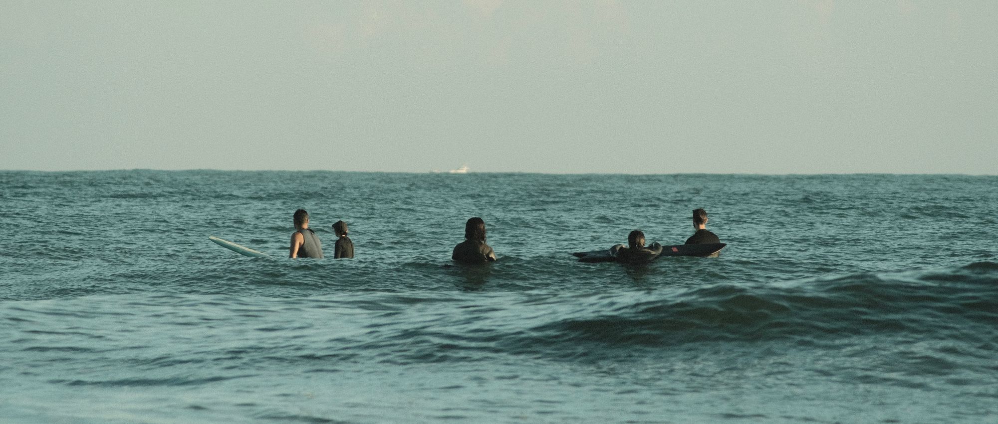 A group of surfer sitting at golden hour in Onjuku, Japan